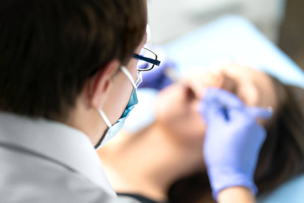 Dentist or dental hygienist in operation with patient. Woman with calculus or caries. Oral doctor removing wisdom teeth. Dentistry. Specialist operating. Checkup with orthodontist or odontologist.